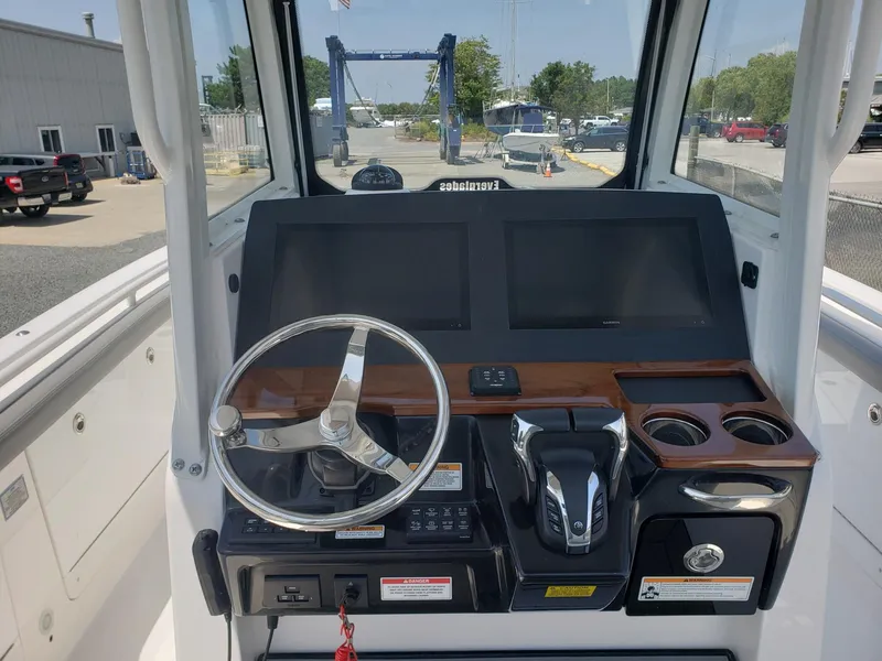 Slide: The Image of 2023 Everglades 285CC boat dashboard with steering wheel and dual screens. - 10