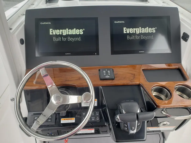 Slide: The Image of 2023 Everglades 285CC boat dashboard with dual Garmin displays and steering wheel. - 11