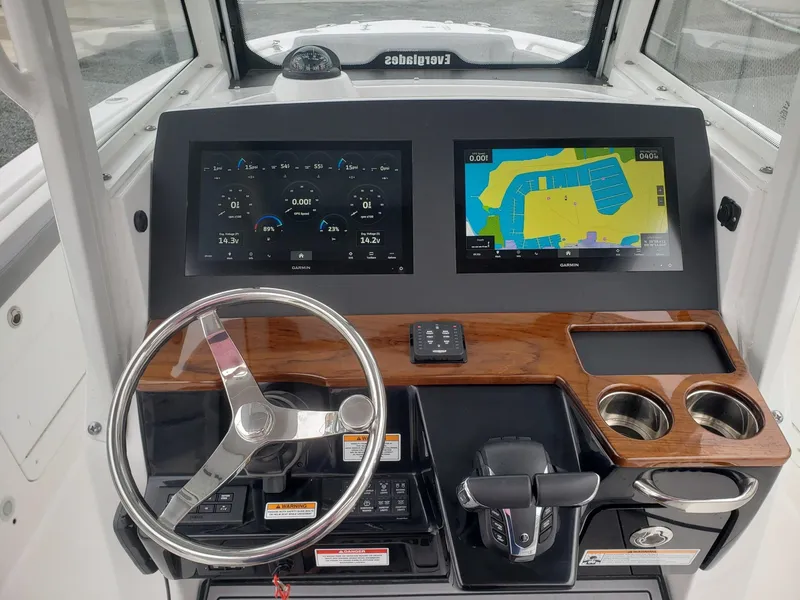 Slide: The Image of 2023 Everglades 285CC boat dashboard with dual screens and steering wheel. - 12