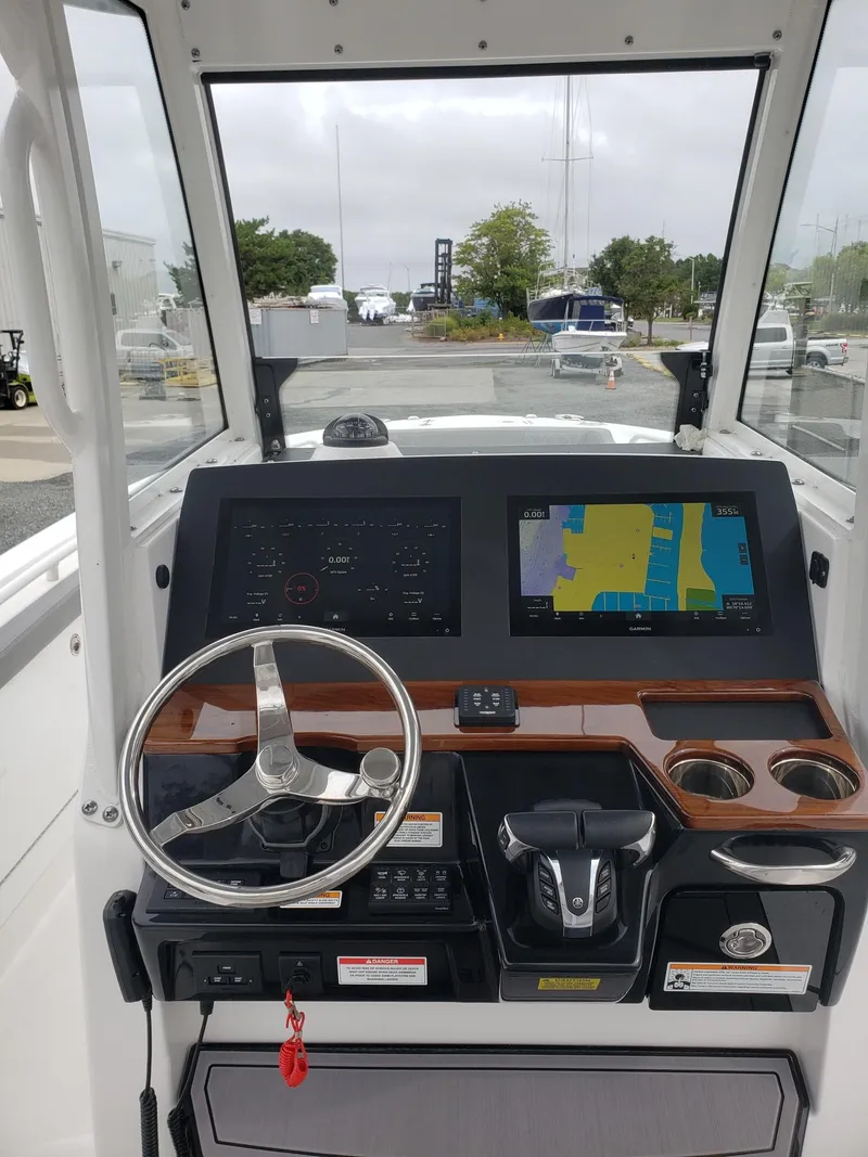 Slide: The Image of 2023 Everglades 285CC boat dashboard with navigation screens and steering wheel. - 13