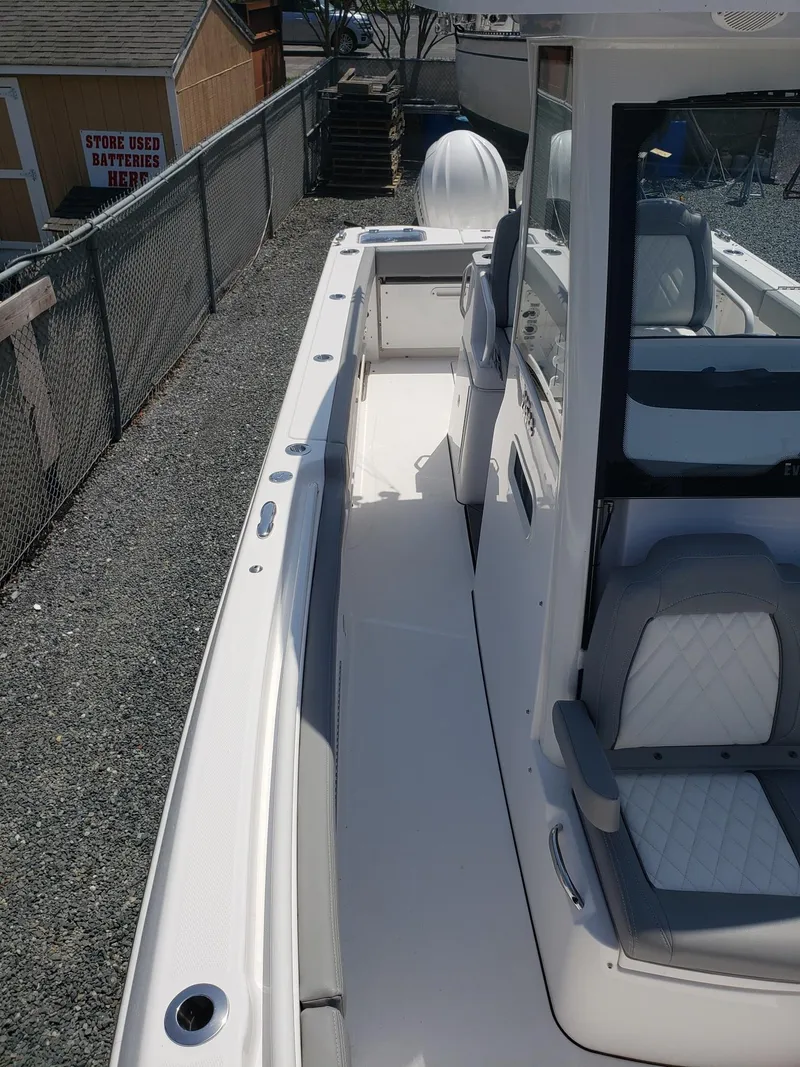 Slide: The Image of 2023 Everglades 285CC boat, sleek white deck, modern seating, outdoor setting. - 16