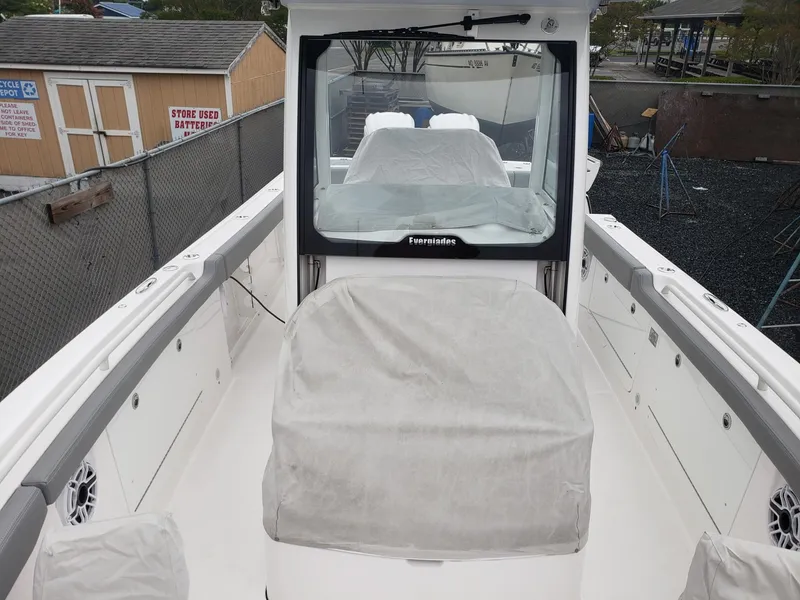 Slide: The Image of 2023 Everglades 285CC boat interior with covered seating and console, docked outdoors. - 22