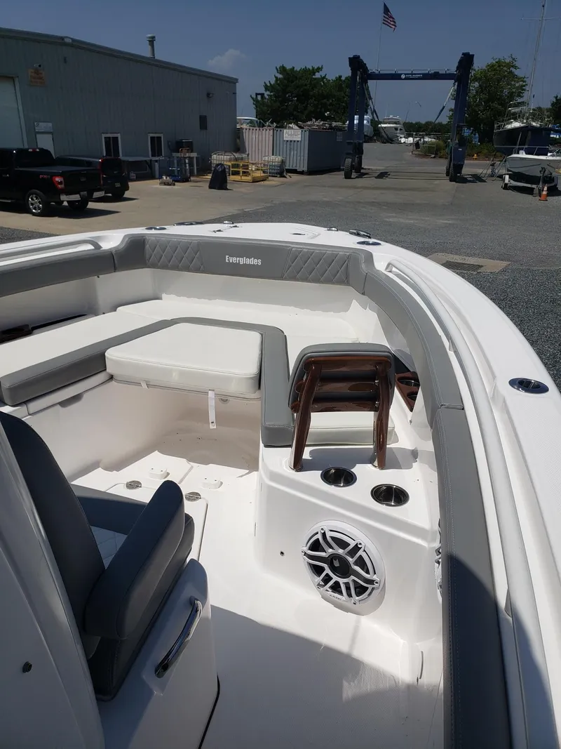 Slide: The Image of 2023 Everglades 285CC boat interior with seating and speaker, docked outdoors. - 24