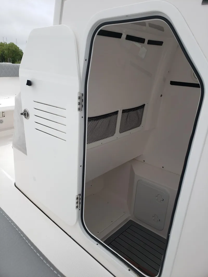 Slide: The Image of 2023 Everglades 285CC boat cabin interior with open door, showcasing storage space. - 27