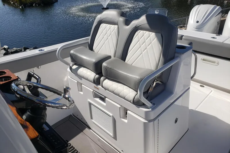 Slide: The Image of 2023 Everglades 285CC boat helm with dual gray leather seats and steering wheel. - 32