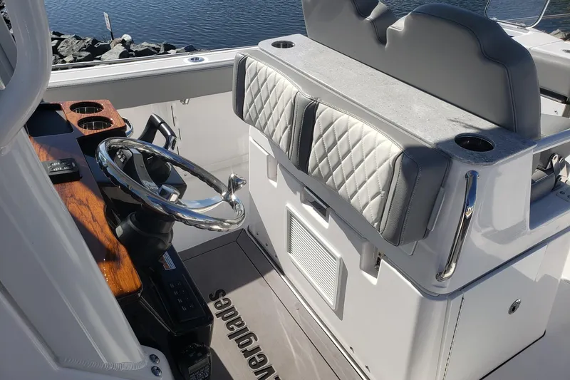 Slide: The Image of 2023 Everglades 285CC boat interior with steering wheel and cushioned seating. - 33