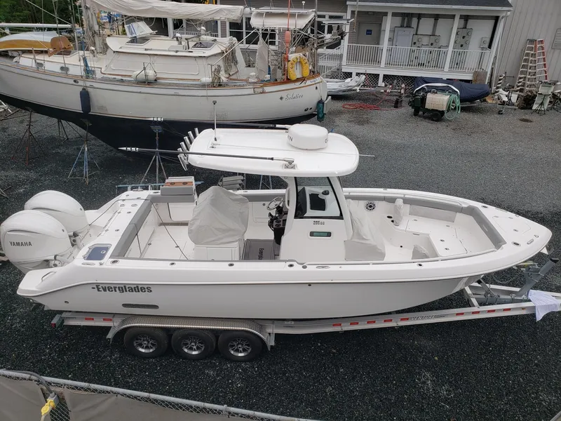 Slide: The Image of 2023 Everglades 285CC boat on trailer, parked in a marina. - 5