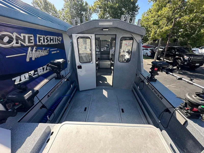 Slide: The Image of 2025 KingFisher 2225 Escape HT boat interior with fishing equipment and outdoor view. - 13