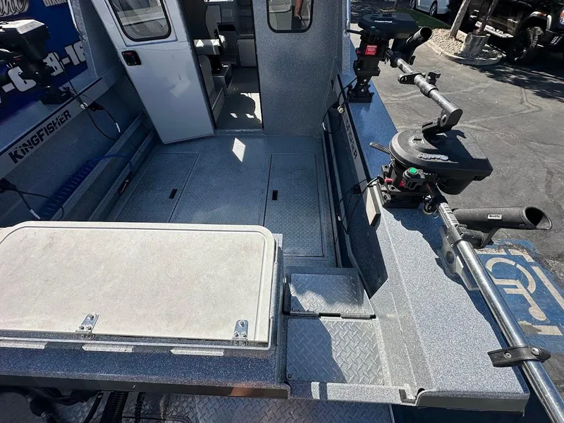 Slide: The Image of 2025 KingFisher 2225 Escape HT boat interior with fishing rod holders and storage compartments. - 14