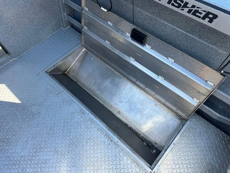 Slide: The Image of Open storage compartment on 2025 KingFisher 2225 Escape HT boat, featuring diamond plate flooring. - 24