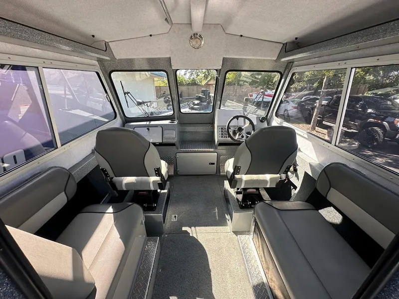 Slide: The Image of Interior of 2025 KingFisher 2225 Escape HT boat, featuring seating and steering area. - 29