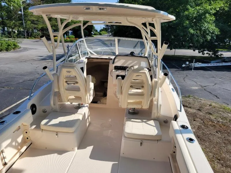 Slide: The Image of 2025 Grady-White Adventure 218 boat interior with seating and helm, parked outdoors. - 12