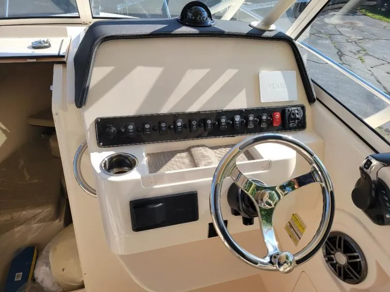 Slide: The Image of 2025 Grady-White Adventure 218 boat dashboard with steering wheel and control panel. - 14