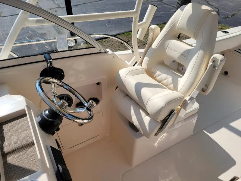 Slide: The Image of 2025 Grady-White Adventure 218 boat interior with steering wheel and captain's chair. - 15