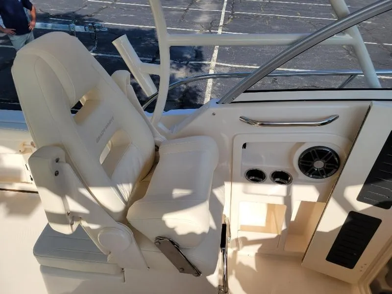 Slide: The Image of 2025 Grady-White Adventure 218 boat interior with white captain's chair and control panel. - 17