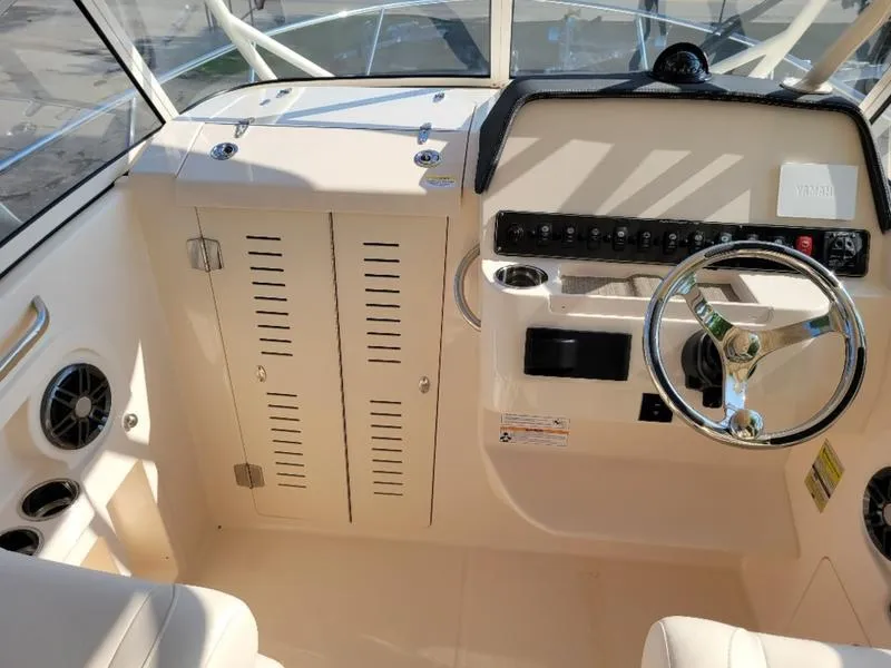 Slide: The Image of 2025 Grady-White Adventure 218 boat interior with steering wheel and control panel. - 19