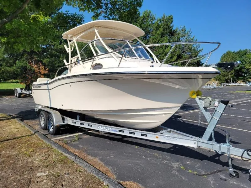 Slide: The Image of 2025 Grady-White Adventure 218 boat on trailer in sunny parking lot. - 3