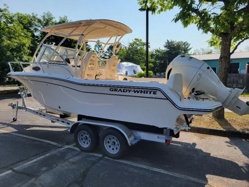 Slide: The Image of 2025 Grady-White Adventure 218 boat on trailer in sunny parking lot. - 6
