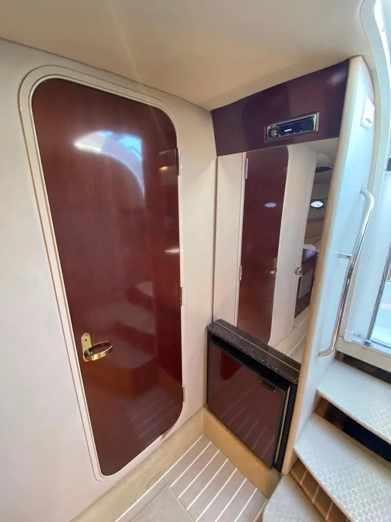 Slide: The Image of Interior of a 2004 Formula 370 Super Sport boat with wooden doors and compact fridge. - 24