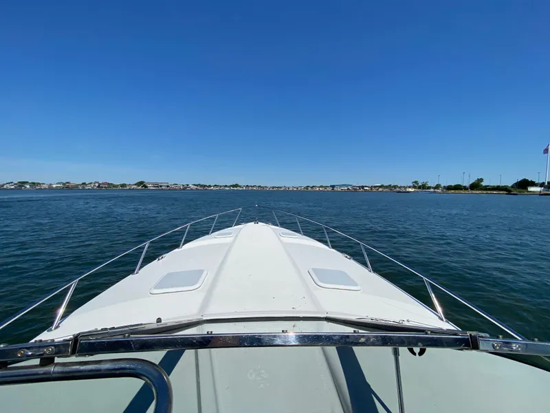 Slide: The Image of 2004 Formula 370 Super Sport boat cruising on a calm lake under a clear blue sky. - 6