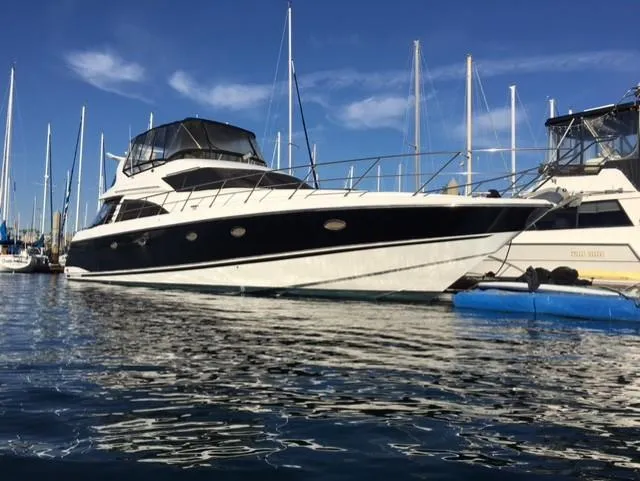 The Image of 1995 Sunseeker MANHATTAN yacht docked in marina, clear sky, calm water. - 0