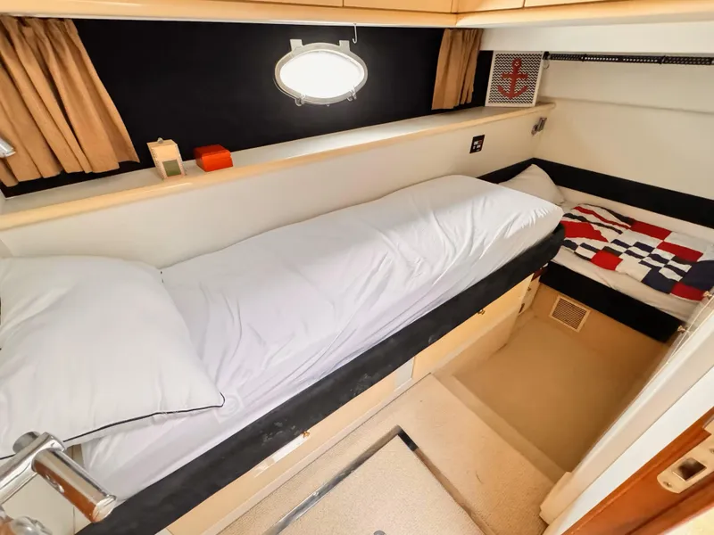 Slide: The Image of 1995 Sunseeker MANHATTAN yacht cabin with cozy beds and nautical decor. - 19