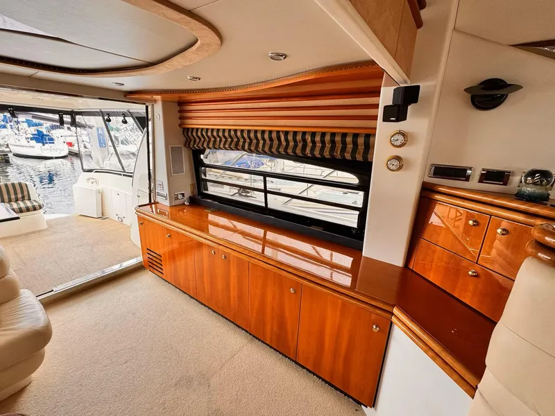 Slide: The Image of Luxurious interior of a 1995 Sunseeker Manhattan yacht with wooden cabinetry and marina view. - 2