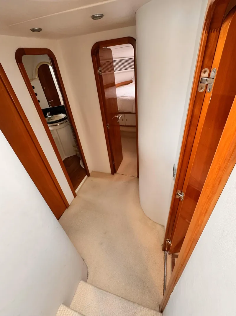 Slide: The Image of Interior hallway of a 1995 Sunseeker Manhattan yacht with wooden doors and carpeted floor. - 22