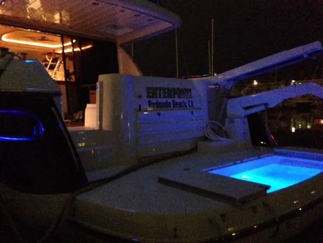 Slide: The Image of Sunseeker MANHATTAN 1995 yacht at night, featuring illuminated deck and interior. - 28