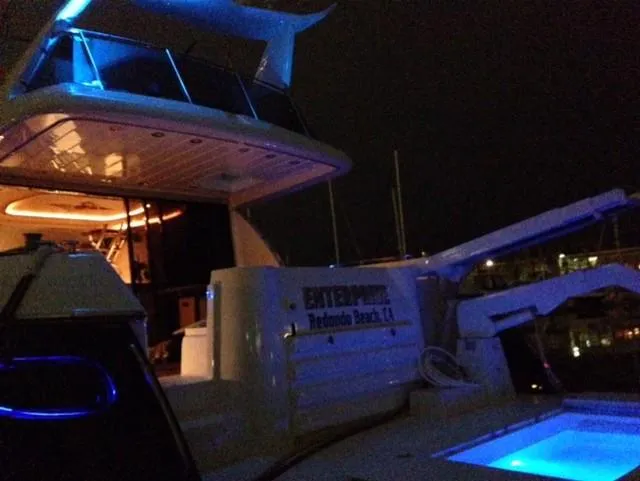 Slide: The Image of Sunseeker MANHATTAN 1995 yacht with blue lighting at night, docked at a marina. - 29
