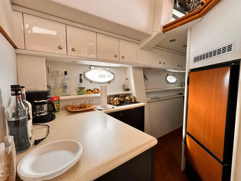 Slide: The Image of Interior of 1995 Sunseeker MANHATTAN yacht kitchen with modern amenities and wooden cabinetry. - 8