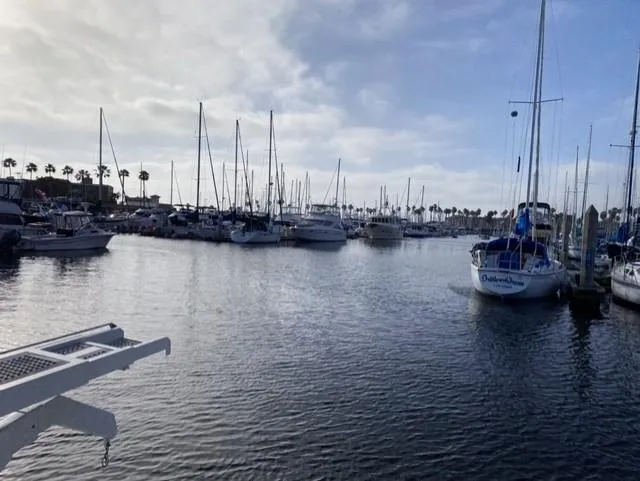 Slide: The Image of Marina with various sailboats, including a 1995 Sunseeker MANHATTAN, under a cloudy sky. - 31