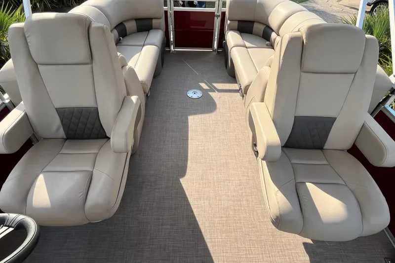 Slide: The Image of 2024 Sun Tracker Party Barge 24 DLX interior with beige seating and spacious layout. - 6