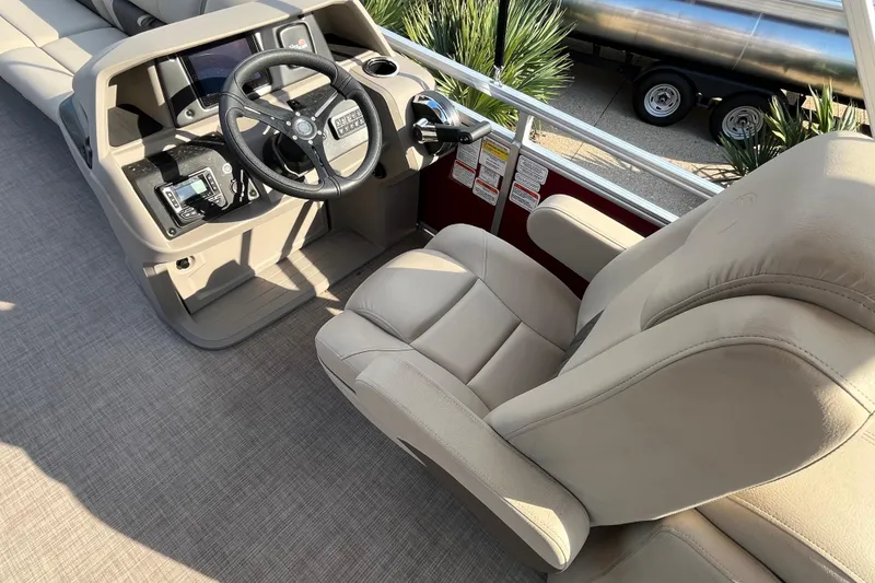Slide: The Image of 2024 Sun Tracker Party Barge 24 DLX helm with beige captain's chair and steering console. - 9