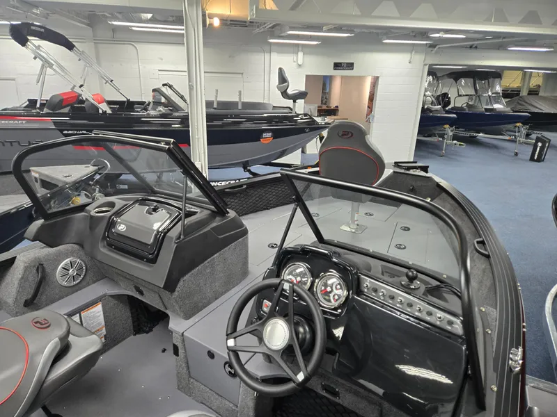 Slide: The Image of 2024 Princecraft Xpedition 200 boat interior with modern dashboard and seating in showroom. - 9