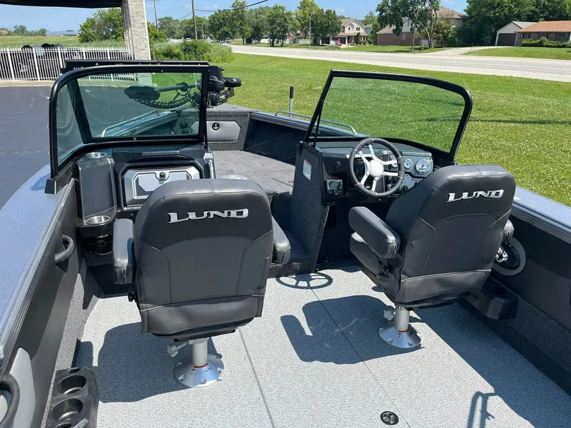 Slide: The Image of 2025 Lund 2275 Baron boat interior with two black seats and steering console. - 11