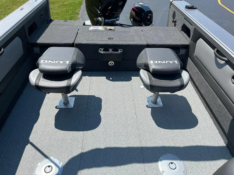 Slide: The Image of 2025 Lund 2275 Baron boat interior with two swivel seats and motor. - 15