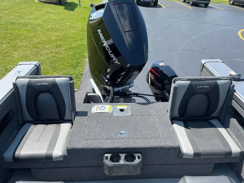 Slide: The Image of 2025 Lund 2275 Baron boat interior with Mercury engine, featuring comfortable seating and cup holders. - 17