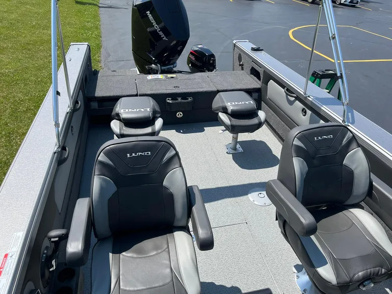 Slide: The Image of 2025 Lund 2275 Baron boat interior with four black seats and a motor. - 18