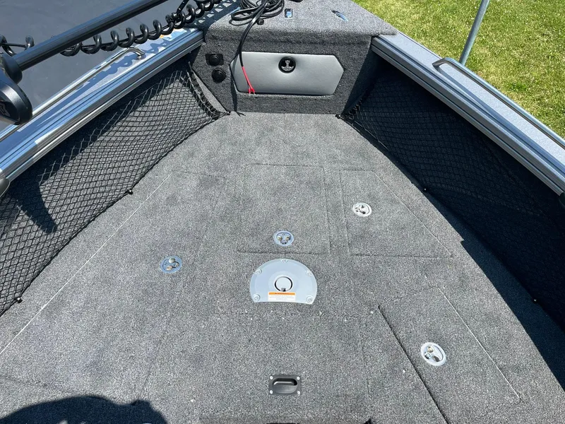 Slide: The Image of 2025 Lund 2275 Baron boat interior with carpeted deck and storage compartments. - 19