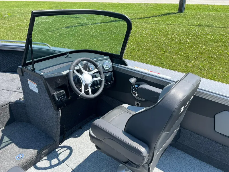 Slide: The Image of 2025 Lund 2275 Baron boat interior with steering wheel and captain's chair. - 21