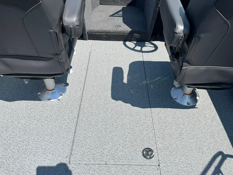Slide: The Image of 2025 Lund 2275 Baron boat interior with two black seats and gray flooring. - 26