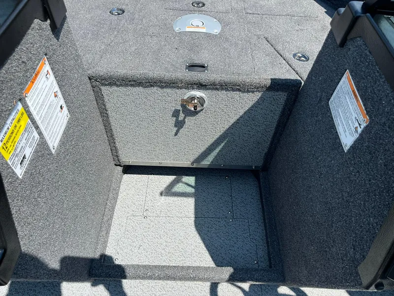 Slide: The Image of 2025 Lund 2275 Baron boat storage compartment with lock and safety labels. - 30