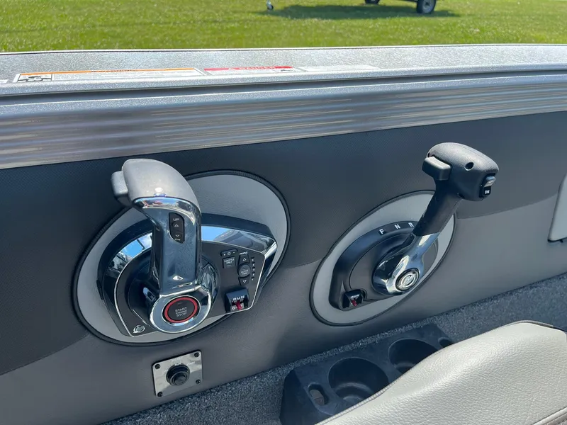 Slide: The Image of 2025 Lund 2275 Baron boat controls with dual levers and cup holders. - 35