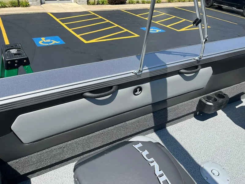 Slide: The Image of 2025 Lund 2275 Baron boat interior with seating and parking lot in background. - 36