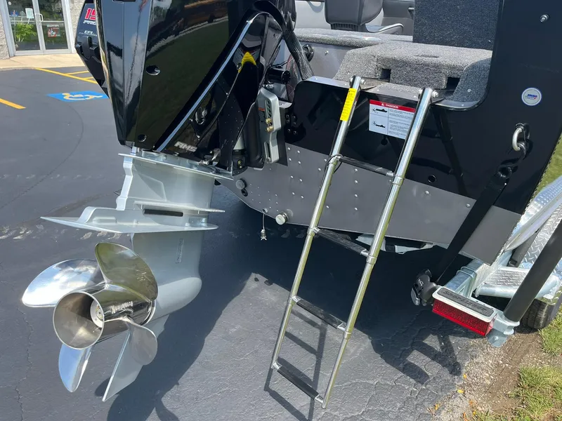 Slide: The Image of 2025 Lund 2275 Baron boat with outboard motor and ladder on a sunny day. - 46