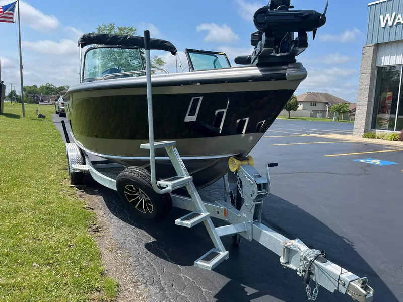 Slide: The Image of 2025 Lund 2275 Baron boat on trailer, parked outdoors near a building. - 5