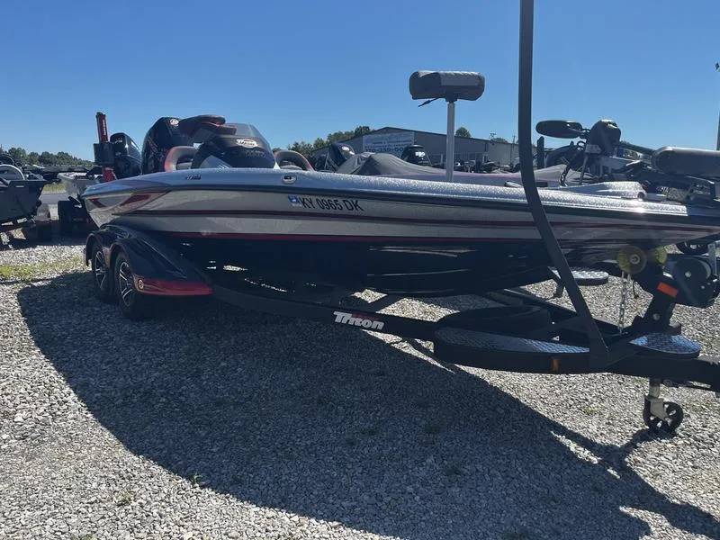 The Image of 2022 Triton 20 TRX MIDWAY boat on a trailer in a gravel lot. - 2