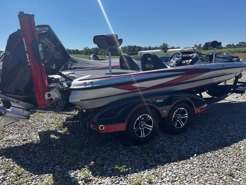 Slide: The Image of 2022 Triton 20 TRX MIDWAY bass boat on a trailer in a gravel lot. - 3