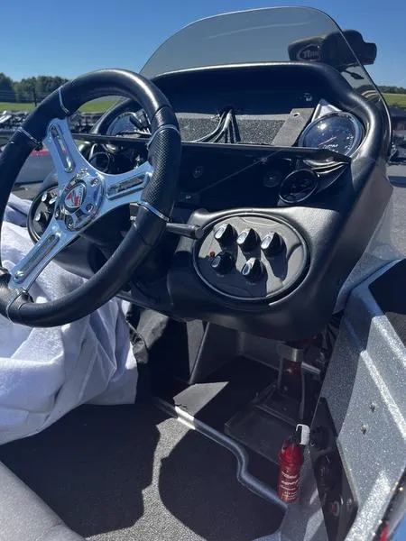 Slide: The Image of 2022 Triton 20 TRX MIDWAY boat dashboard with steering wheel and control panel. - 7